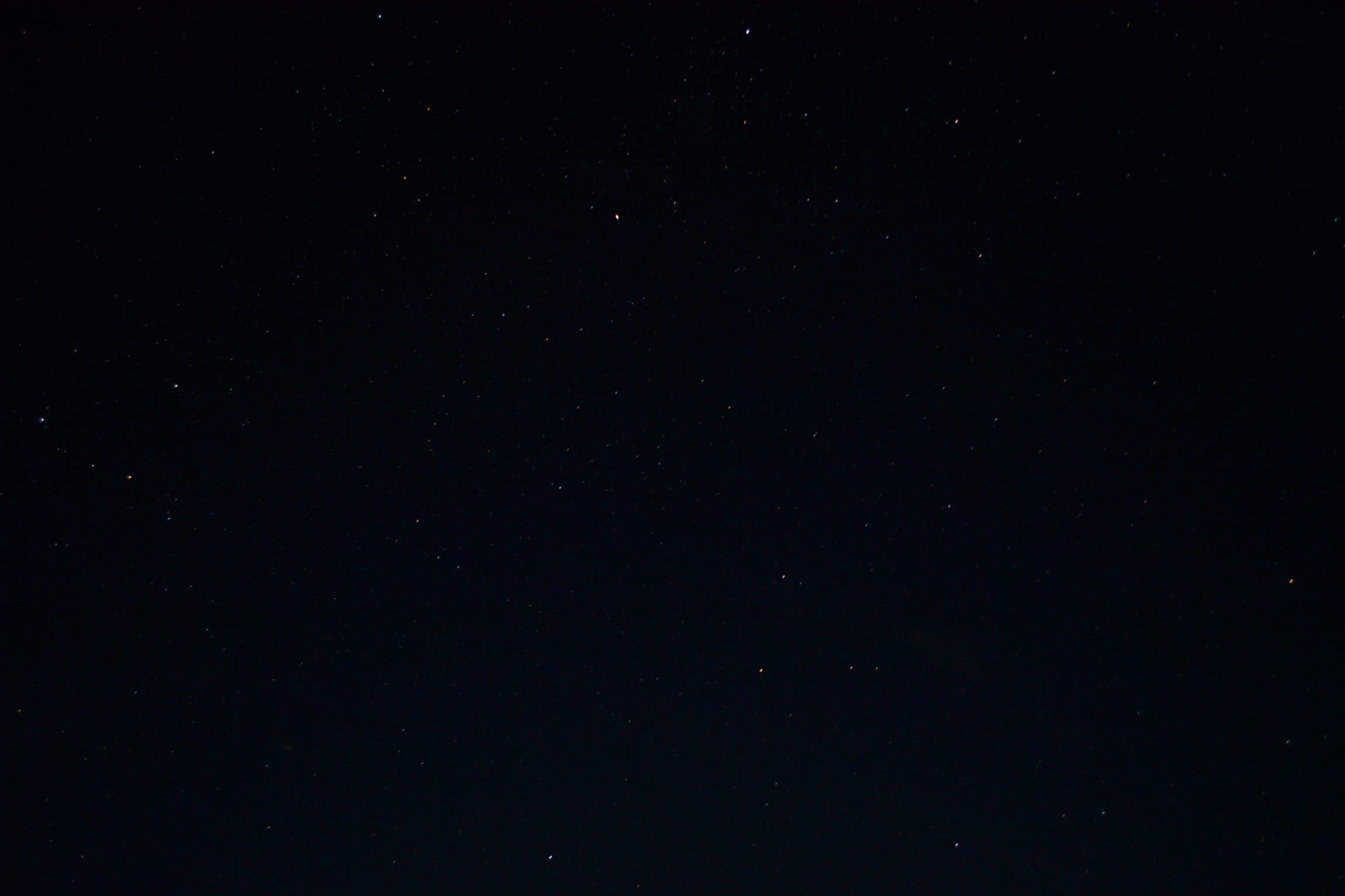 a night sky with stars and a few clouds